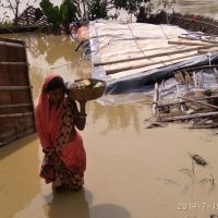 Woman carrying food through flood waters