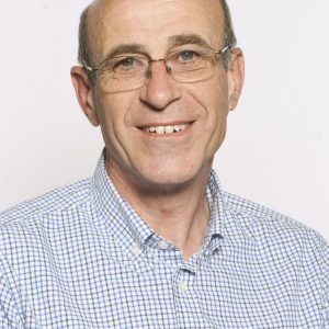 John Thompson head and shoulders image - a man in a blue checked shirt and glasses