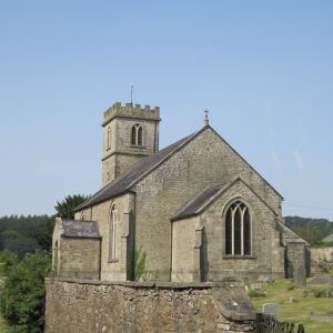 A picture of a stone church with blue sky behind it