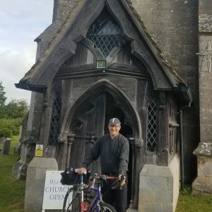 Image of Mark with his bike outside a church