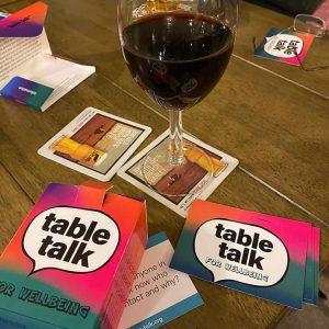 Table Talk cards on a pub table with a glass of wine