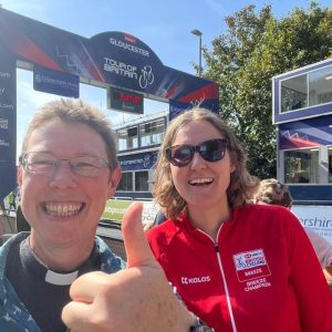 Jo Pestell and Henrietta standing at the Tour of Britain finish line in the sun