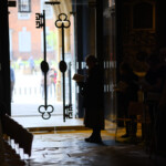 Cathedral Stewards in silhouette inside the South entrance to Gloucester Cathedral