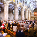 Congregation faces towards the reading of the Gospel in the centre of the nave of Gloucester Cathedral
